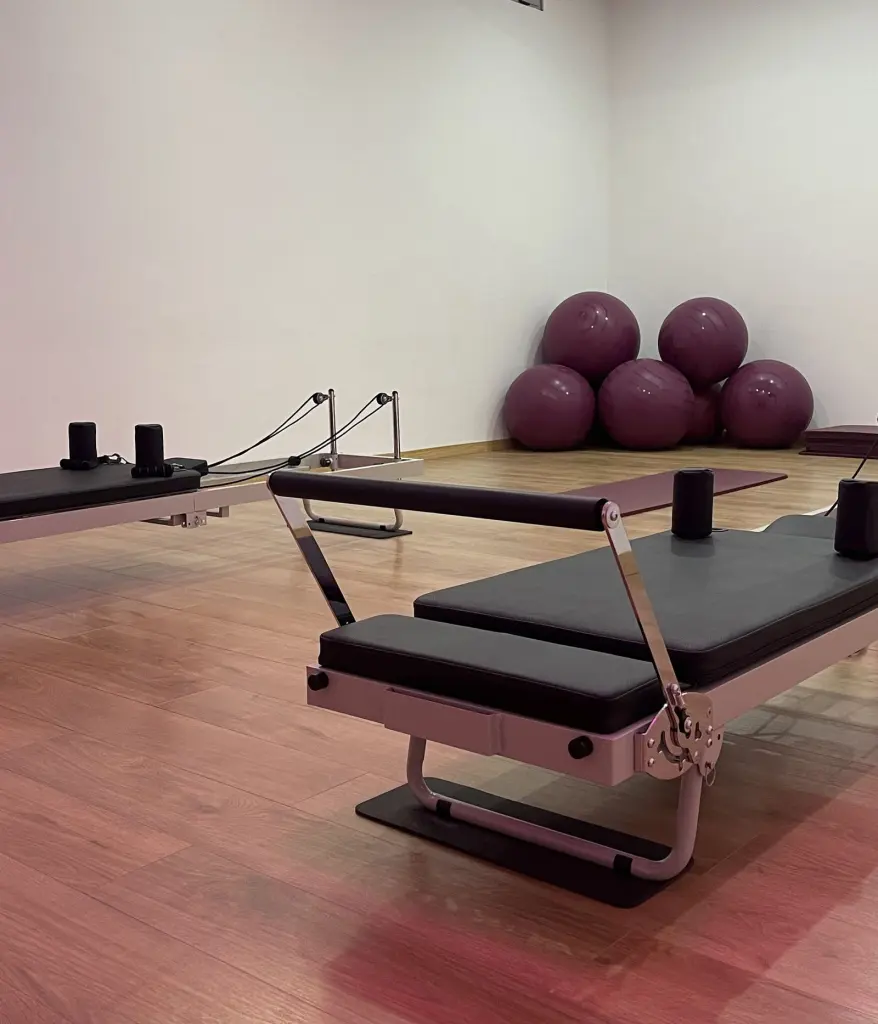 Sala do estúdio da Charneca de Caparica, com aparelhos de Pilates e bolas de exercício junto à parede